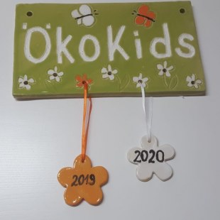 Keramiktafel mit ÖkoKikds Logo und Jahreszahlblumenanhängern für die Auszeichnung des Kindergartens | © C. Günnewig