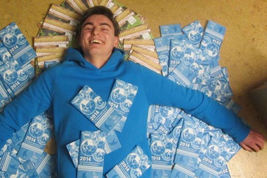 Johannes Kronau liegt am Boden, bedeckt von vielen Flyern der NAJU