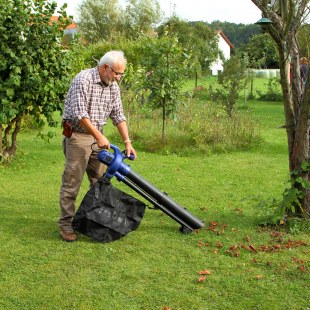 Ein älterer Mann steht auf einer Streuobstwiese und bedient einen Laubsauger | © Heinz Tuschl