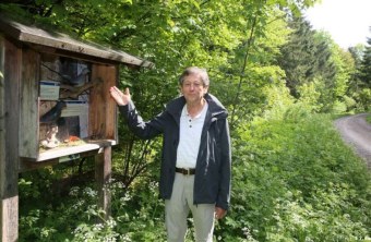 Robert Mecklinger steht vor einem Schaukasten am Wegrand und erklärt etwas | © LBV
