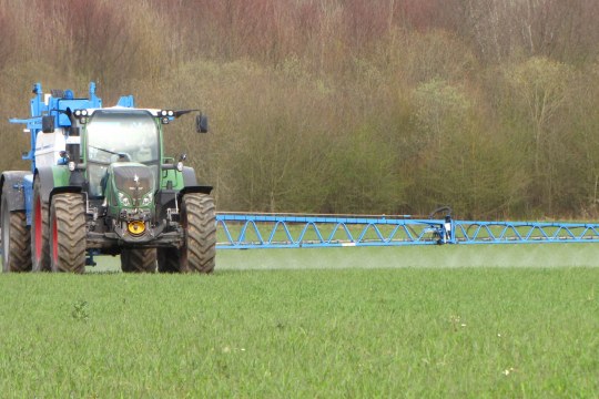 Ein Traktor fährt auf einem Acker und sprüht Gift | © Thomas Staab