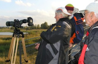 Drei ältere Herren stehen an einem Spektiv auf der Vogelinsel im Altmühlsee | © Christiane Geidel