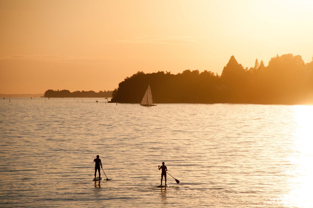 Zwei Stehpaddler in der Abenddämmerung auf einem See | © Felix Ulrich (Pixabay)