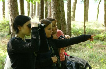 Drei weiblichen Bundesfreiwillige beobachten im Wald Vögel mit einem Fernglas | © Martina Widuch