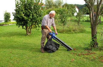 Ein älterer Mann steht auf einer Streuobstwiese und bedient einen Laubsauger | © Heinz Tuschl