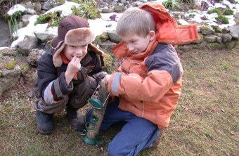 Zwei Kinder sitzen am Boden mit einer gefüllten Futtersäule in der Hand | © Birgit Helbig