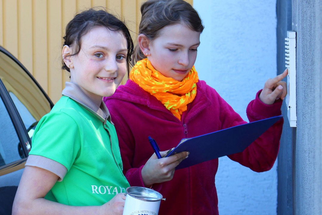 Zwei Schülerinnen klingeln an einer Tür um für die Sammelwoche Geld zu sammeln | © Carola Bria