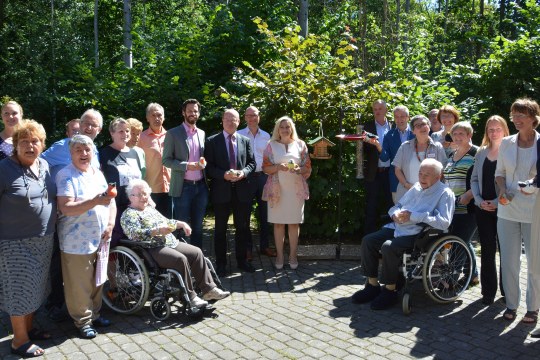 Gruppenbild mit Dame: Staatsministerin Melanie Huml (Bildmitte, mit Blaumeise) zusammen mit Projektbeteiligten und BewohnerInnen im AWO-Pflegeheim Wendelstein | © Isabel Krieger