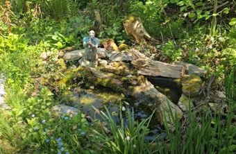 Ein idyllischer Naturgarten mit Teich und Skulptur zeigt die Vielfalt der Natur, gefördert durch den LBV.