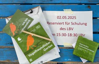 Schulungsunterlagen des LBV auf einem blauen Tisch, mit Vogelmotiv und Hinweis auf ein Seminar am 02.05.2025.
