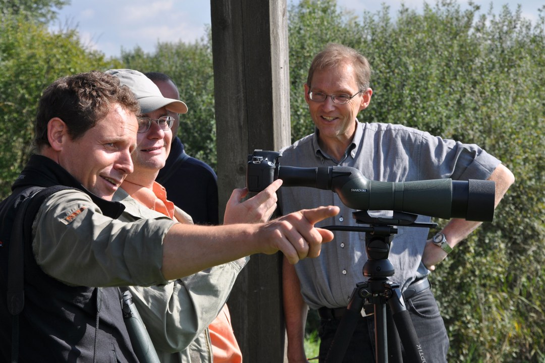 Drei Männer beim Digiscopie-Workshop am Altmühlsee. Alle drei stehen um ein Spektiv. | © LBV
