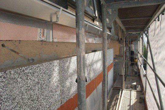 Bei einer Baustelle an einem Haus wird eine neue Dämmung gebaut, man sieht durch ein Gerüst | © LBV