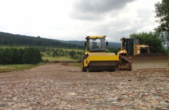 Zwei Fahrzeuge planieren eine Straße | © Thomas Staab
