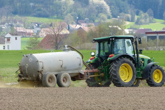 Traktor bringt Gülle auf einem Feld aus | © Peter Bria