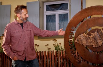 Christian Söder neben dem Logo des Flatterhauses | © Günther Fischer