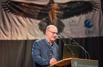 LBV-Vorsitzender Dr. Norbert Schäffer auf der Delegiertenversammlung 2023 am Rednerpult, im Hintergrund ist ein Bartgeierbanner | © Tobias Tschapka