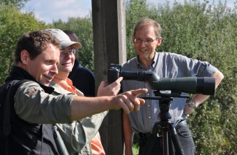 Drei Männer beim Digiscopie-Workshop am Altmühlsee. Alle drei stehen um ein Spektiv. | © LBV