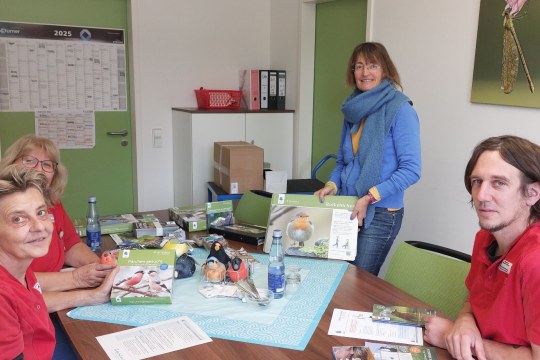 Vier Personen diskutieren am Tisch über Naturschutzmaterialien des LBV in Wassertrüdingen. | © Günter Möbus