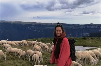 Christina im Urlaub vor einer Herde Schafe