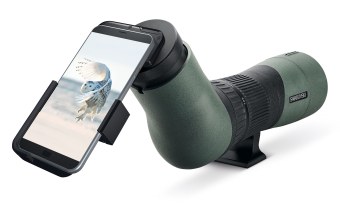 Smartphone ist mit einem Adapter an einem Swarovski-Spektiv befestigt, auf dem Display sieht man eine fliegende Schneeeule | © Swarovski Optik