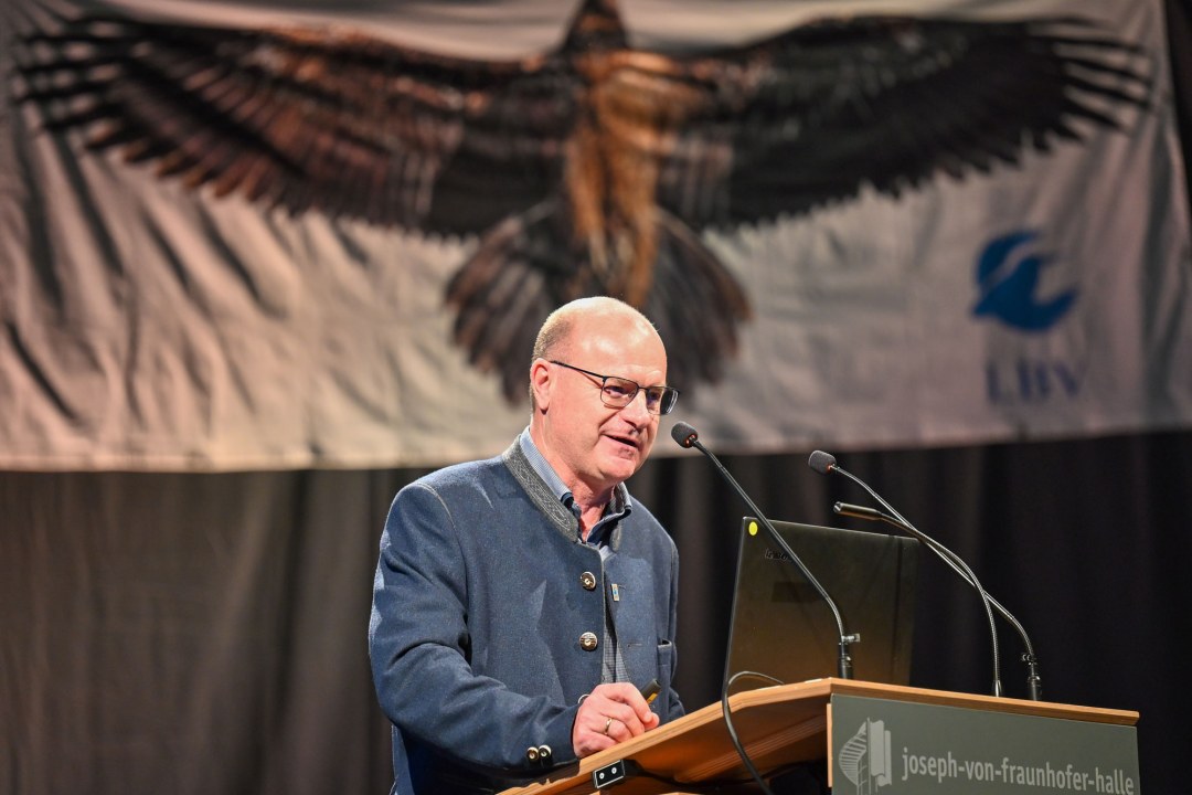 LBV-Vorsitzender Dr. Norbert Schäffer auf der Delegiertenversammlung 2023 am Rednerpult, im Hintergrund ist ein Bartgeierbanner | © Tobias Tschapka