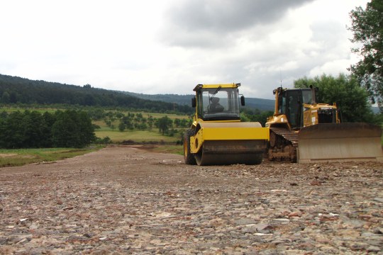Zwei Fahrzeuge planieren eine Straße | © Thomas Staab