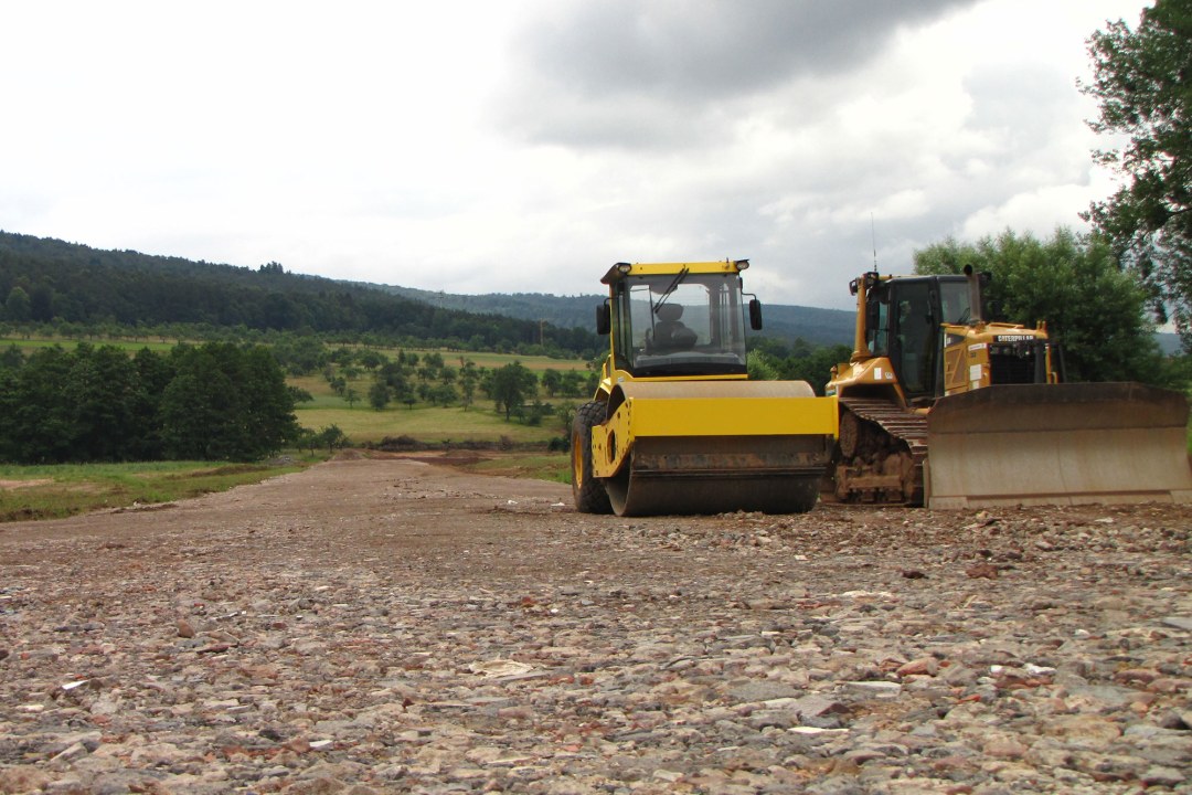 Zwei Fahrzeuge planieren eine Straße | © Thomas Staab