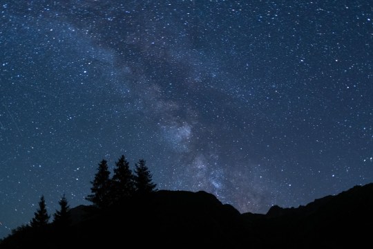 Die Milchstraße leuchtet über den Bergen, man sieht schwarze Baum und Bergsilhouetten | © Dr. Olaf Broders