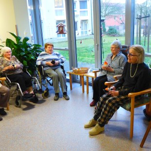 Mehrere Seniorinnen sitzen zusammen vor dem Vogelfenster unterhalten sich | © Burkhard von Seckendorff Heim