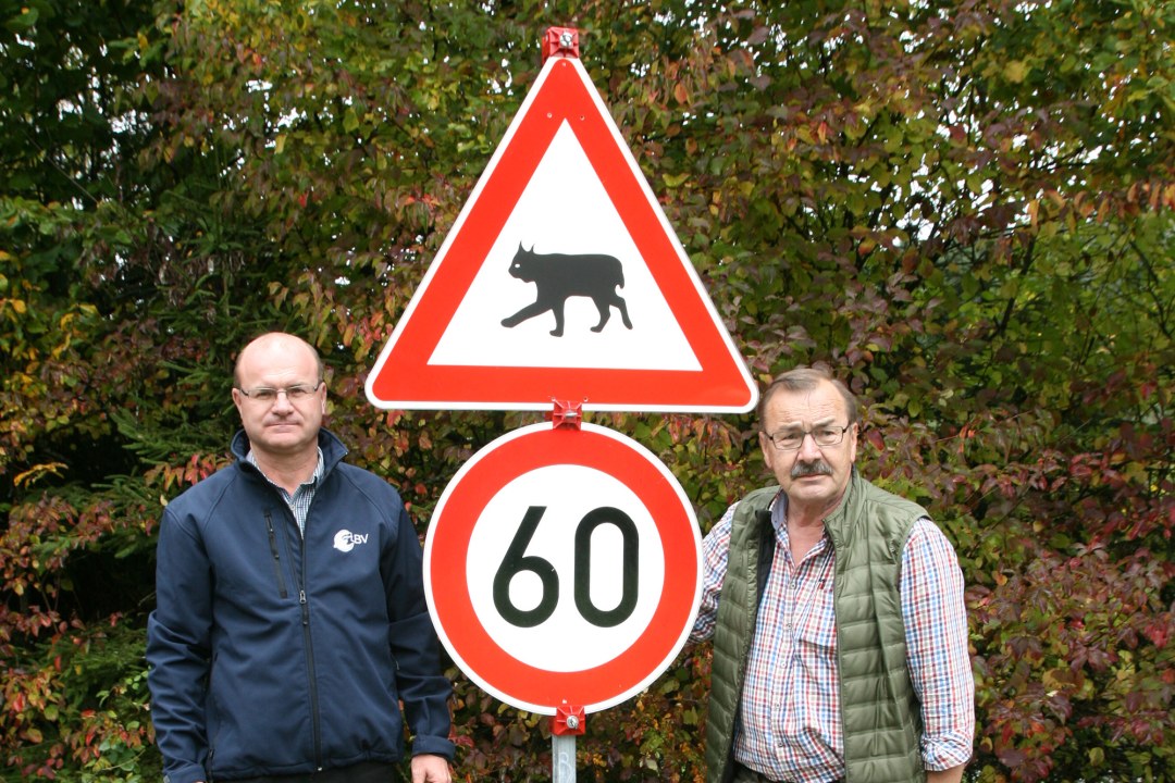 Der LBV-Vorsitzende Dr. Norbert Schäffer und der LBV-Kreisgruppenvorsitzende Wolfgang Reichenberger stehen vor einem möglichen Luchswarnschild mit Geschwindigkeitsbegrenzung auf 60 km/h | © Anna Schäffer