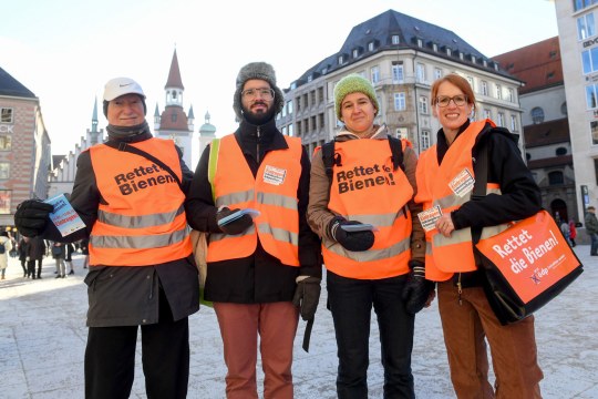 Vier Menschen sind mit orangefarbenen Warnwesten bekleidet auf denen "Rettet die Bienen" steht. Sie sind Rathauslotsen | © Tobias Hase