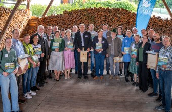 Eine Gruppe von Menschen posiert bei der Auszeichnung für den Kiebitzschutz 2025 vor einem LBV-Banner.