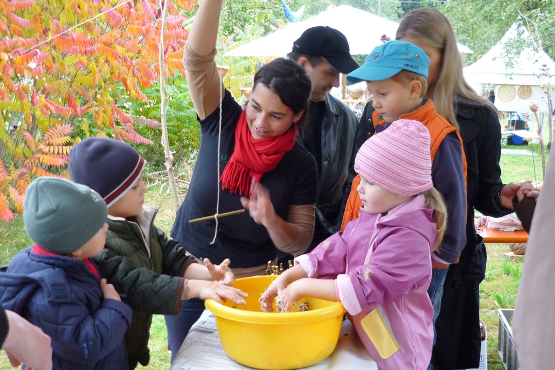 Vier Kinder lernen von einer erwachsenen Frau, wie sie Vogelfutter selbst herstellen können | © Doris Lundgreen