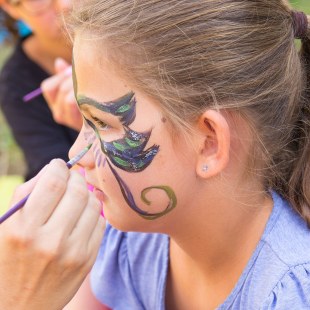 Ein Mädchen wird mit den schillernden Farben des Stars im Gesicht bemalt | © memo AG